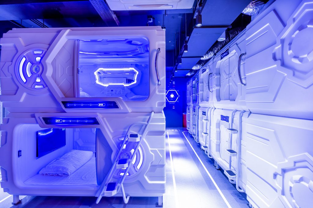 Interior view of a MET A Space Pod capsule showing the built-in bed, lighting, and control panel design